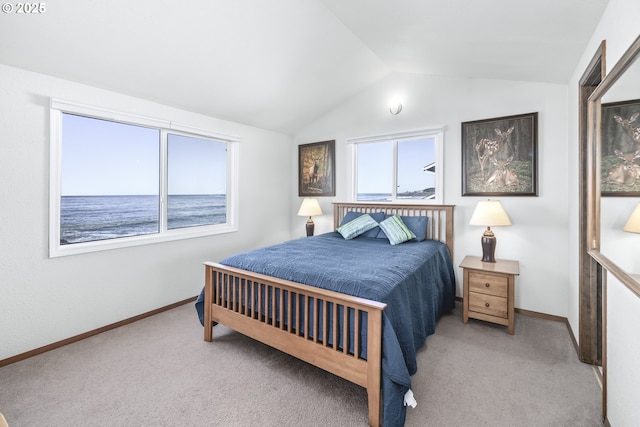 carpeted bedroom with vaulted ceiling and a water view