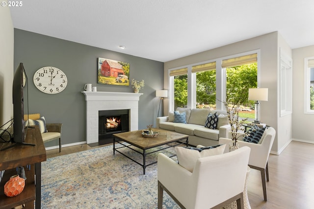 living area with wood finished floors, baseboards, a fireplace, and recessed lighting