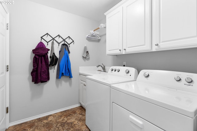 laundry area featuring washing machine and dryer, baseboards, and cabinet space