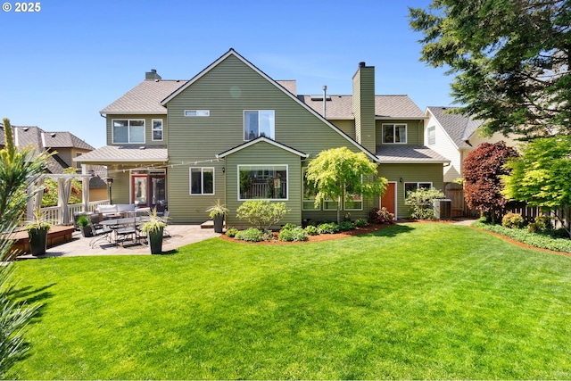 back of property with a chimney, central AC unit, an outdoor living space, and a patio