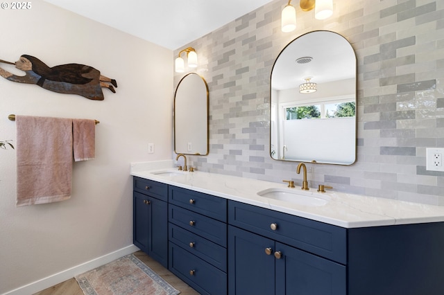 full bathroom featuring baseboards, double vanity, and decorative backsplash