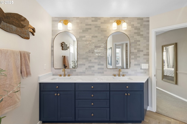 bathroom featuring baseboards and double vanity