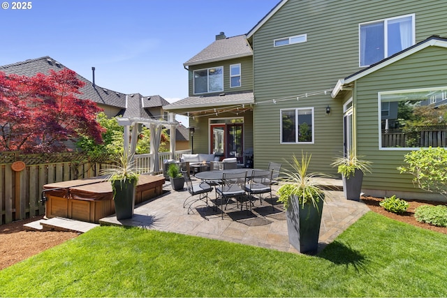back of house with a hot tub, a patio area, roof with shingles, and outdoor lounge area