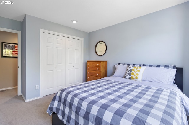 bedroom with carpet, baseboards, and a closet
