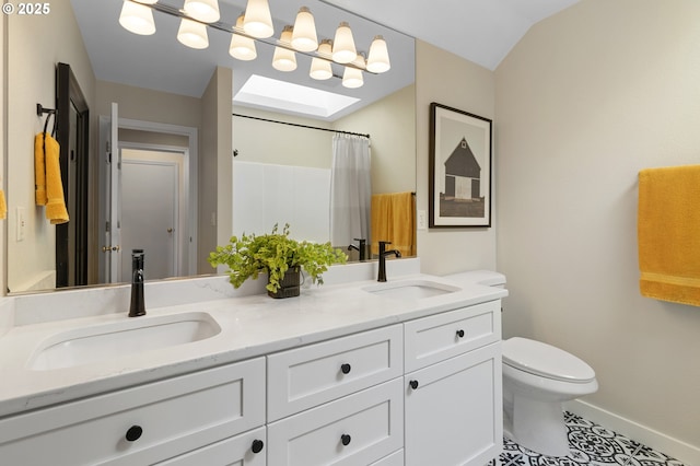 bathroom featuring toilet, double vanity, baseboards, tile patterned flooring, and a skylight