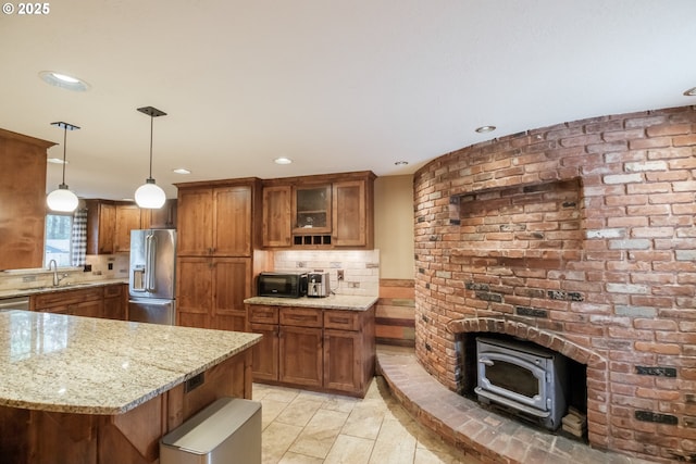 4635 18th Pl S, Salem, OR 97302 - kitchen featuring stainless steel fridge, brown cabinetry, a wood stove, tasteful backsplash, and recessed lighting