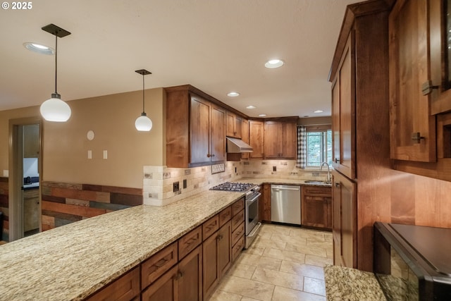 4635 18th Pl S, Salem, OR 97302 - kitchen featuring stainless steel appliances, under cabinet range hood, a sink, light stone counters, and backsplash