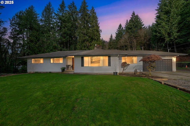 ranch-style home featuring a lawn and a garage