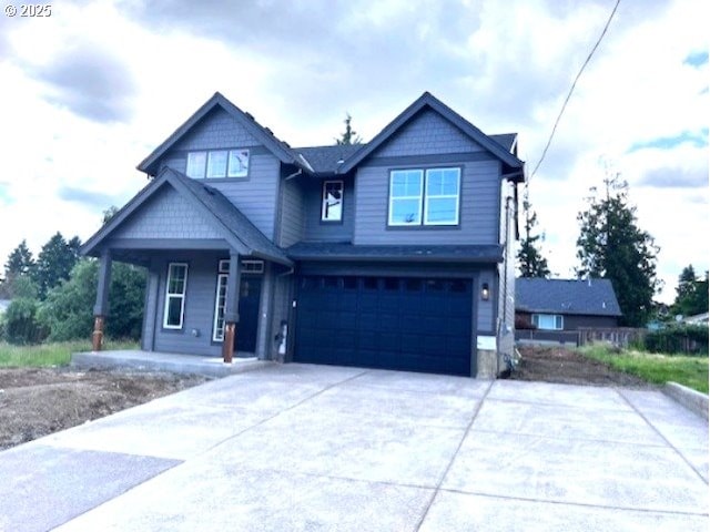 craftsman inspired home with covered porch, an attached garage, and concrete driveway