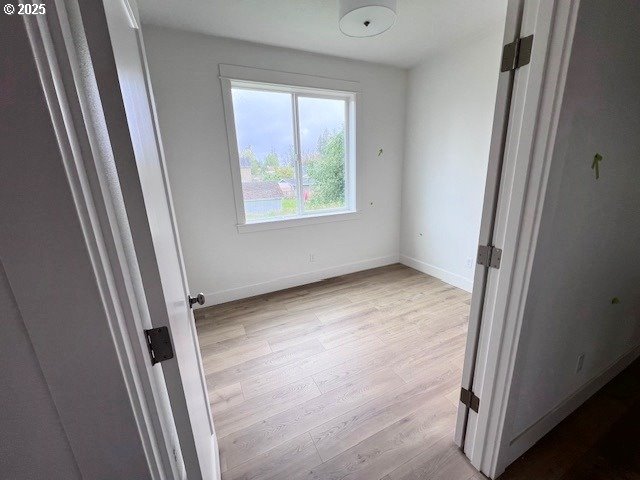 unfurnished bedroom with light wood-style floors and baseboards
