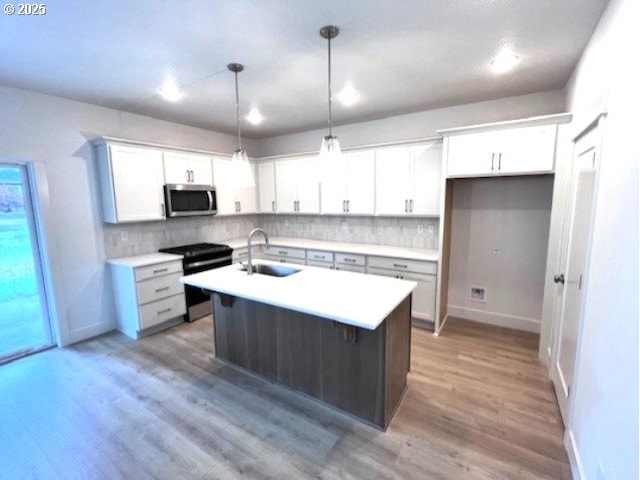 kitchen with stainless steel microwave, electric range oven, tasteful backsplash, and light countertops