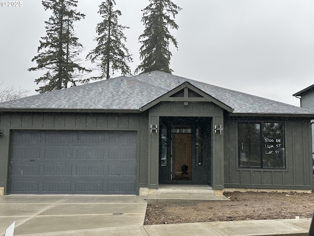 view of front facade featuring a garage, board and batten siding, driveway, and a shingled roof