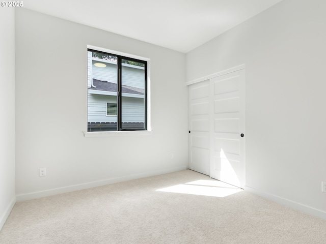 unfurnished bedroom featuring carpet floors, baseboards, and a closet
