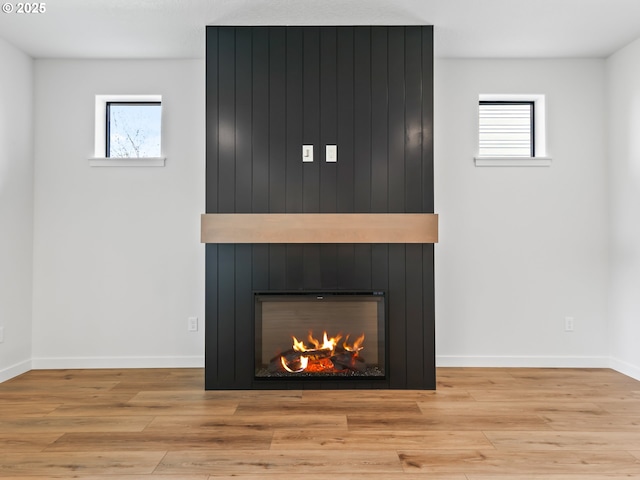 details with a fireplace, baseboards, and wood finished floors