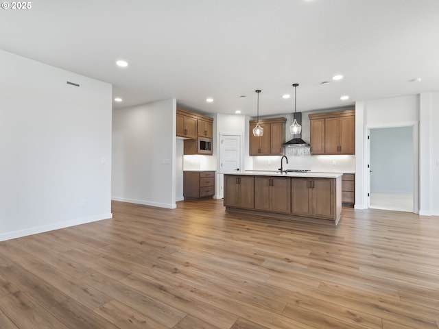 kitchen with wall chimney range hood, recessed lighting, and stainless steel microwave