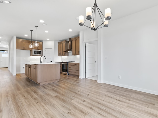 kitchen with wall chimney range hood, electric stove, light wood-style floors, and stainless steel microwave