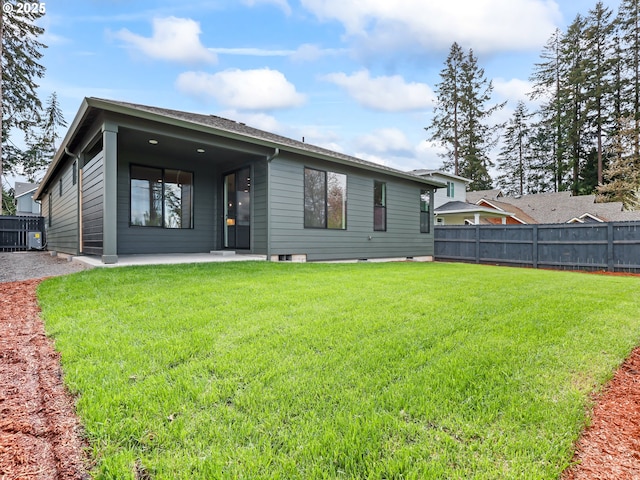 rear view of property with a patio area, fence, and a lawn