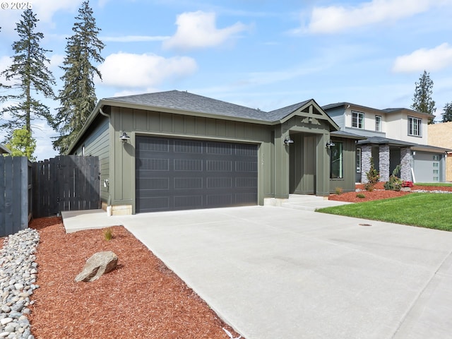 prairie-style home with board and batten siding, a garage, fence, a shingled roof, and driveway