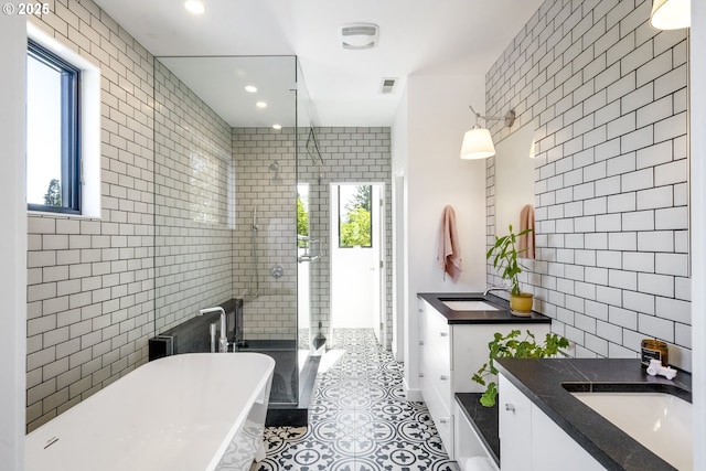 3419 SE Woodward St, Portland, OR 97202 - full bath with tile walls, plenty of natural light, vanity, tile patterned flooring, and a freestanding bath