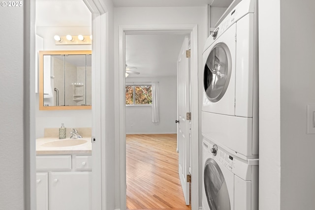 4071 Donald St Unit E, Eugene, OR 97405 - laundry area featuring stacked washing machine and dryer, light wood-type flooring, and a ceiling fan