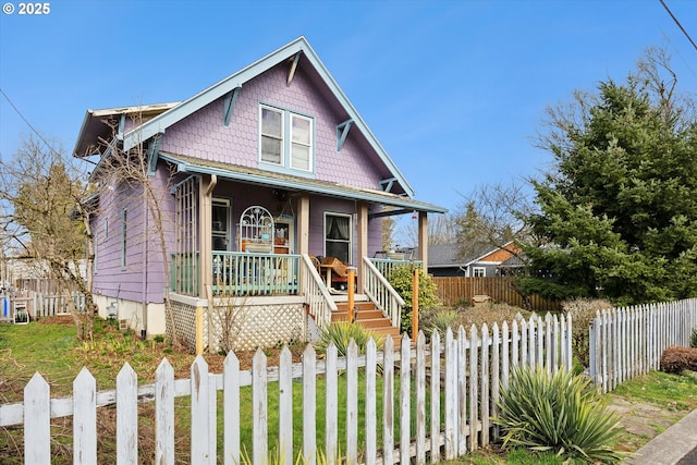 bungalow-style house featuring covered porch and a fenced front yard