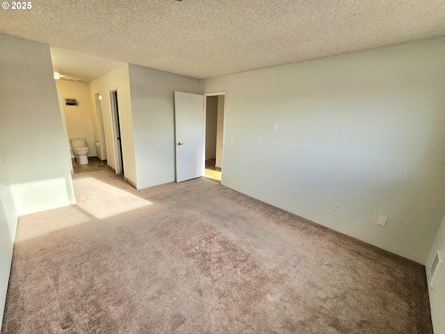 empty room with light carpet and a textured ceiling