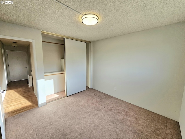 950 Evergreen Rd Unit 207, Woodburn, OR 97071 - unfurnished bedroom with carpet floors, a closet, and a textured ceiling