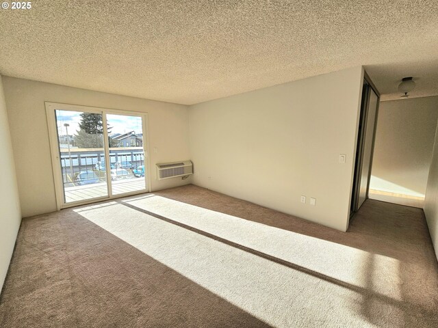950 Evergreen Rd Unit 207, Woodburn, OR 97071 - carpeted spare room featuring a wall mounted air conditioner and a textured ceiling