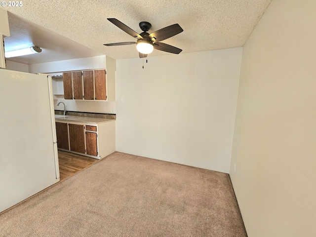 950 Evergreen Rd Unit 207, Woodburn, OR 97071 - kitchen featuring freestanding refrigerator, light colored carpet, a sink, ceiling fan, and light countertops