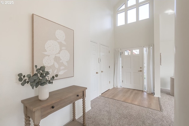 carpeted entrance foyer with a high ceiling