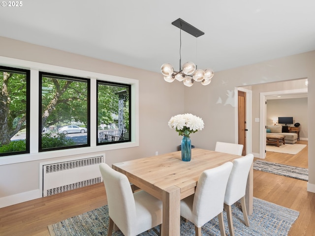 3440 SW 100th Ave, Portland, OR 97225 - dining room featuring radiator heating unit, a chandelier, and light wood-style floors