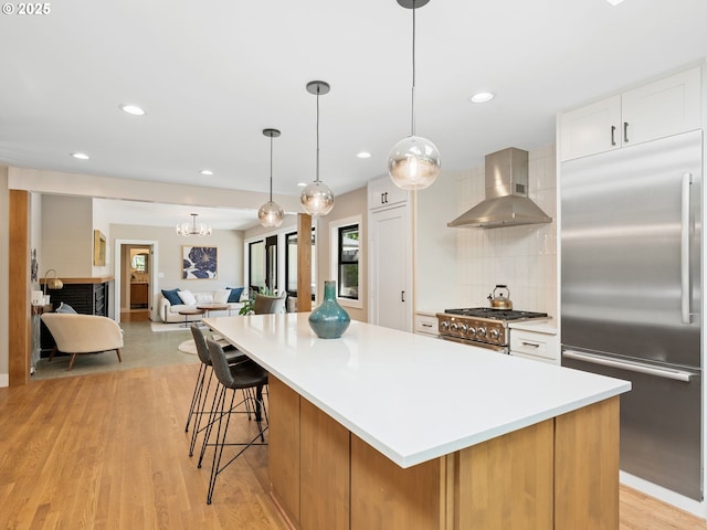 3440 SW 100th Ave, Portland, OR 97225 - kitchen with premium appliances, wall chimney range hood, backsplash, light countertops, and a large island