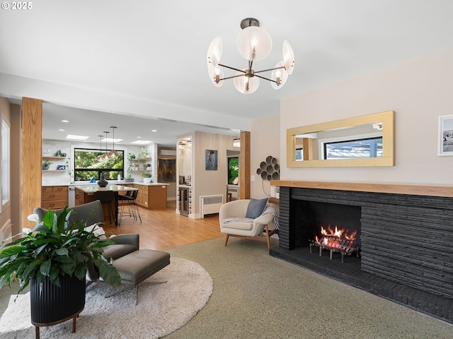 3440 SW 100th Ave, Portland, OR 97225 - living room with radiator heating unit, a brick fireplace, a chandelier, and recessed lighting