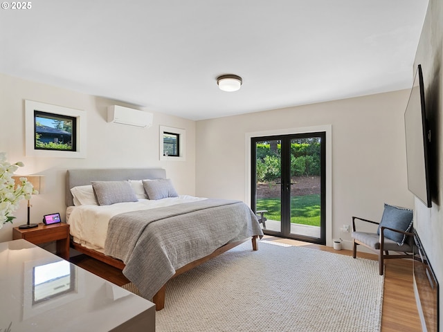 3440 SW 100th Ave, Portland, OR 97225 - bedroom with an AC wall unit, wood finished floors, and access to exterior