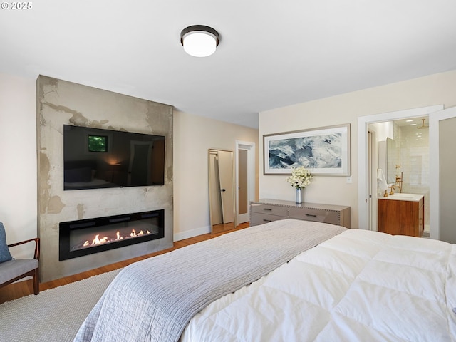 3440 SW 100th Ave, Portland, OR 97225 - bedroom with a large fireplace, wood finished floors, and ensuite bath