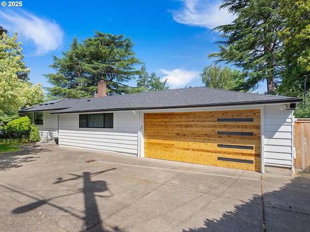 3440 SW 100th Ave, Portland, OR 97225 - view of front of house with driveway, a chimney, roof with shingles, and an attached garage