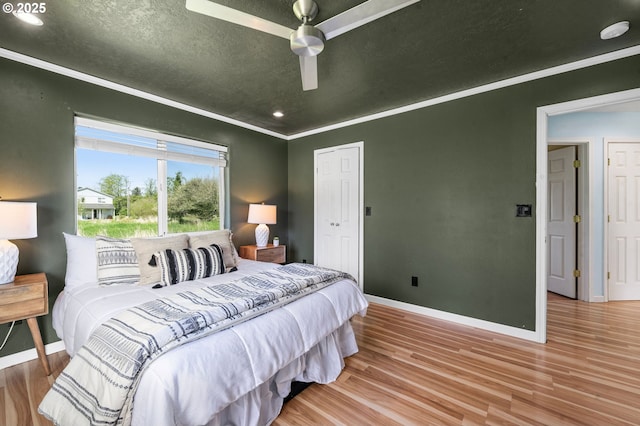 bedroom featuring ceiling fan, recessed lighting, baseboards, wood finished floors, and ornamental molding