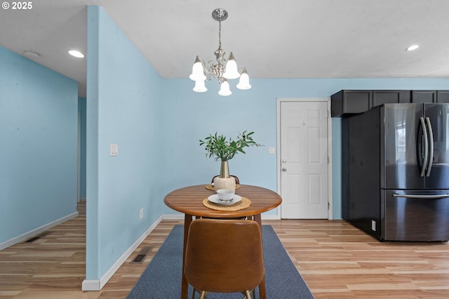 dining space featuring light wood-style floors, recessed lighting, baseboards, and an inviting chandelier