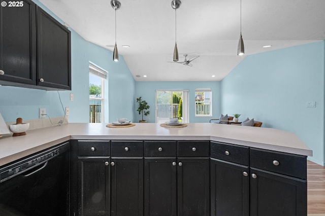 kitchen featuring dishwasher, light countertops, light wood finished floors, a peninsula, and dark cabinets