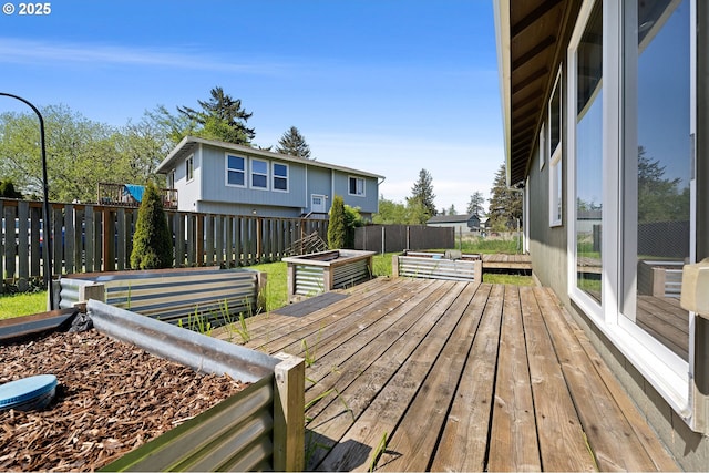 wooden terrace with a fenced backyard