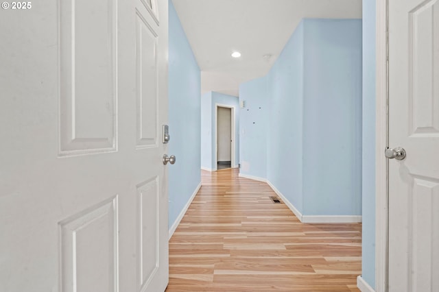 hall with light wood-type flooring, recessed lighting, and baseboards
