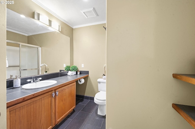 full bathroom featuring a stall shower, vanity, baseboards, toilet, and ornamental molding