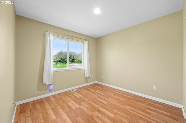 spare room with baseboards, recessed lighting, light wood-style flooring, and visible vents