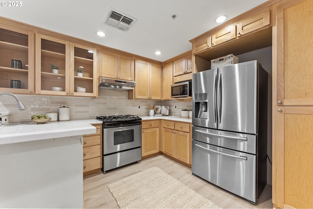 kitchen featuring sink, tasteful backsplash, light hardwood / wood-style floors, light brown cabinetry, and appliances with stainless steel finishes