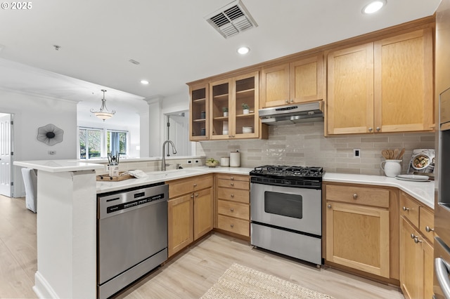 kitchen featuring sink, stainless steel appliances, kitchen peninsula, pendant lighting, and decorative backsplash