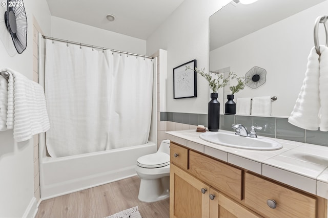 full bathroom with hardwood / wood-style floors, vanity, shower / bath combination with curtain, and toilet