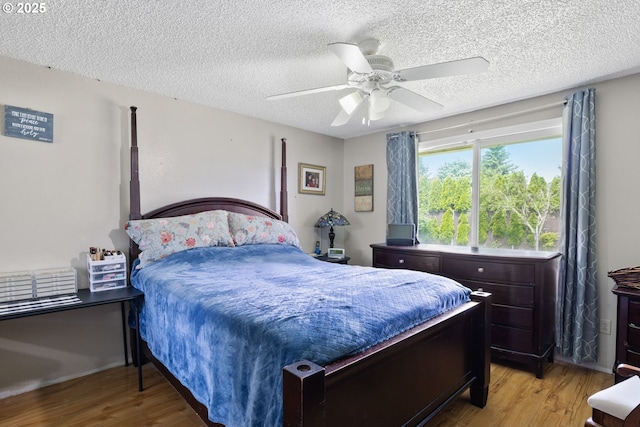 bedroom featuring wood finished floors, a textured ceiling, and ceiling fan