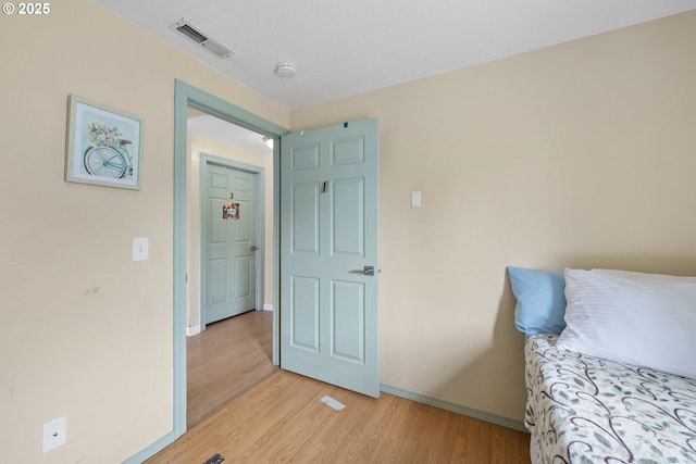 bedroom with light wood finished floors and baseboards