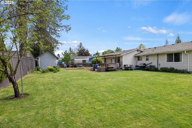 view of yard featuring a deck, an outdoor structure, and a storage shed