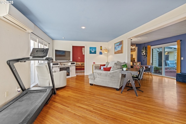 living area featuring recessed lighting, an AC wall unit, a notable chandelier, and light wood-style flooring